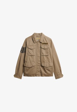 Giacca utility color marrone chiaro in tessuto, con colletto, quattro tasche anteriori e un accento a strisce nere sulla manica.