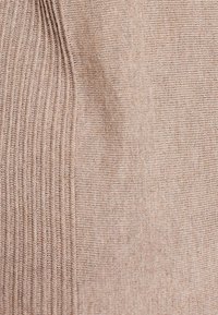 Beżowa dzianina z pionowym prążkowaniem i miękką fakturą. Charakteryzuje się jednolitym wzorem oraz gładką, nieozdobioną powierzchnią.