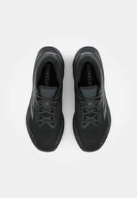 Scarpe da corsa nere con superiore in mesh traspirante, dettagli testurizzati e accenti riflettenti. Presentano lacci grigi e imbottitura per supporto.