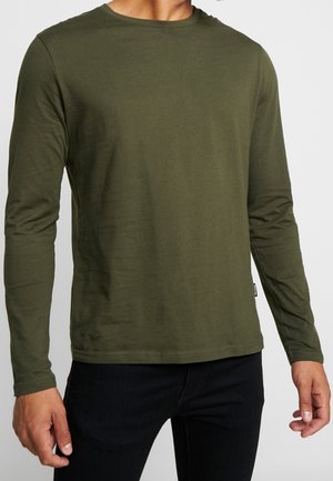 Koszula z długim rękawem w oliwkowym odcieniu, wykonana z miękkiej mieszanki bawełny, z okrągłym dekoltem i dopasowanym krojem. Dyskretna metka marki blisko dołu.
