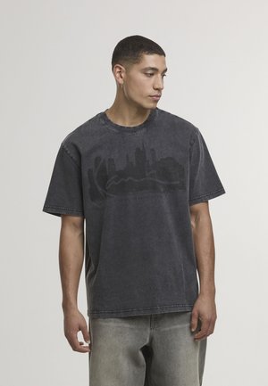 Tmavomodré oversize tričko z bavlny s okrúhlym výstrihom, na prednej strane s čiernou grafikou mestského panoráma, zašité lemovanie a krátke rukávy.