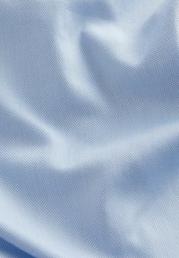 Jasnoniebieska tkanina syntetyczna, gładka w dotyku z delikatnym wzorem siatki, prezentująca łagodne zagięcia i falbany. Odpowiednia do różnych zastosowań.