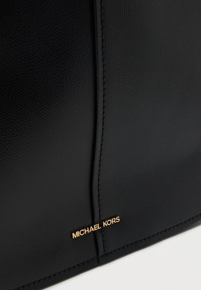 Черна кожена чанта с текстуриран завършек, с златно лого "MICHAEL KORS" и изчистени линии. Опит дизайн без видими закопчалки.