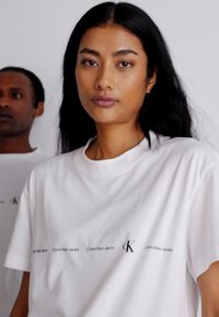 Calvin Klein Jeans LOGO REPEAT - Camiseta estampada - bright white