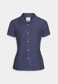 Camicia a maniche corte blu navy con righe bianche verticali, collo a camicia, chiusura con bottoni sul davanti e taschino sul petto. Materiale in misto cotone.