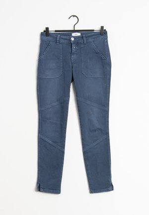 Pantalon slim bleu avec poches avant, passants de ceinture et détails de coutures, suspendu sur un cintre noir sur fond blanc.