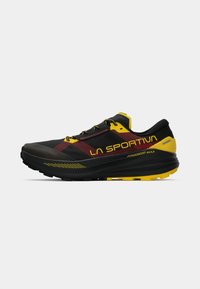 Melna un dzeltena La Sportiva Prodigio Max sporta apavi ar sarkaniem akcentiem, zemas griezuma dizains un mīkstināta zole skriešanai vai āra aktivitātēm.