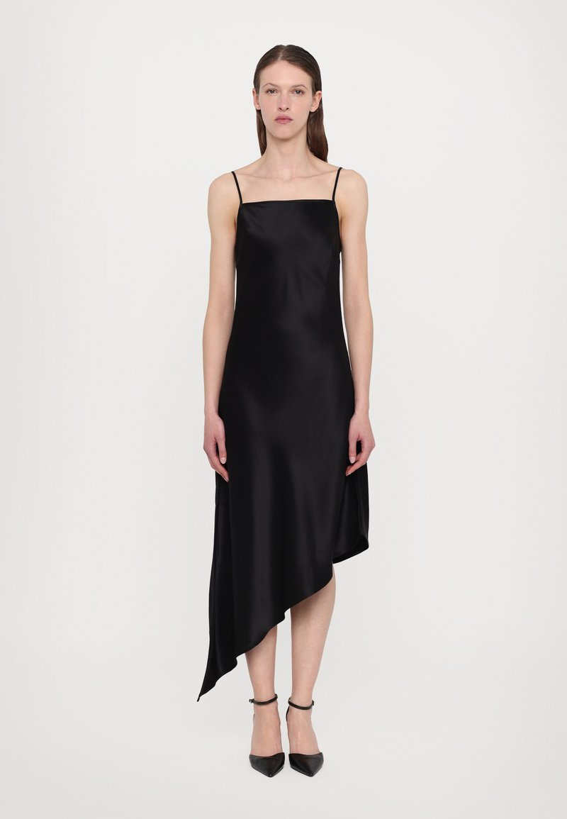 Svart satengdress med tynne stropper, firkantet utringning og asymmetrisk hemline. Jevn tekstur og elegant fall fremhever designet.
