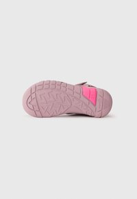 Pink rubber shoe sole featuring a textured tread pattern, with a prominent bright pink accent and molded details for grip and support.
