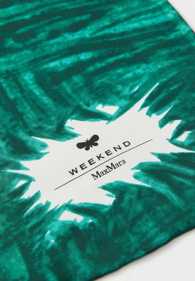 Grønne mønstrede stof med et sprøjtedesign og et hvidt label, der viser "WEEKEND MaxMara" i sort tekst. Tekstureret overflade.