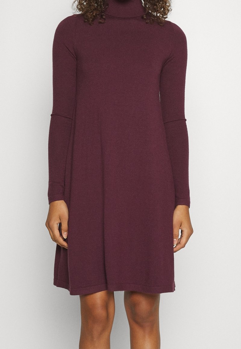 Pitkähihaisen turtleneck-mekon syvä burgundinpunainen. Valmistettu pehmeästä neulekankaasta, jossa on rento mitoitus ja levenevä siluetti.