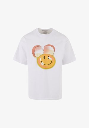 Biała bawełniana koszulka z grafiką uśmiechniętej twarzy na żółtym tle oraz dwoma popękanymi różowymi skorupkami jajek przypominającymi uszy myszy.