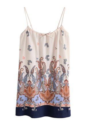 Nahaufnahme einer Hand, die den Saum eines gemusterten Kleides mit blauen, rosa und beigen Paisley-Mustern und einem kleinen goldenen Logo-Anhänger hält.