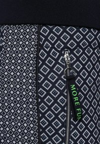 Sweatpants med ett geometriskt diamantmönster i marinblått och vitt, med en dragkedjeficka och en grön "MORE FUN"-etikett. Strukturerat tyg.