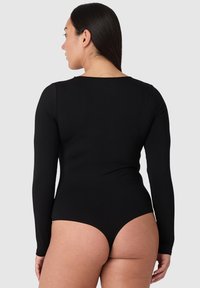 Musta pitkähihaisia body, jossa on syvä selkädesign, valmistettu sileästä, joustavasta materiaalista, jossa on korkeakaarteiset lahkeet ja minimalistiset linjat.