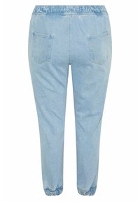 Joggers de mezclilla azul claro con cintura elástica fruncida, dos bolsillos traseros y puños elásticos en los tobillos. Textura suave.