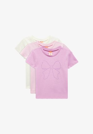 Tres camisetas de manga corta: una blanca, una rosa claro y una lavanda. La camiseta lavanda presenta un gráfico de un lazo púrpura con texto. Tejido de algodón.