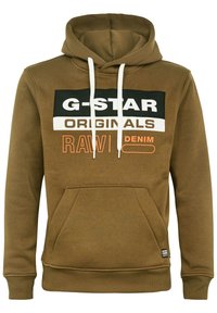 Sudadera marrón con bolsillo tipo canguro en la parte frontal, cordones blancos y texto gráfico en blanco y negro en el pecho. Tejido de mezcla de algodón.