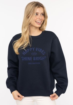 Dunkelblaues Sweatshirt mit Rundhalsausschnitt und langen Ärmeln. Mit gesticktem Text "HAPPY VIBES" und "SHINE BRIGHT" in kontrastierenden Farben.