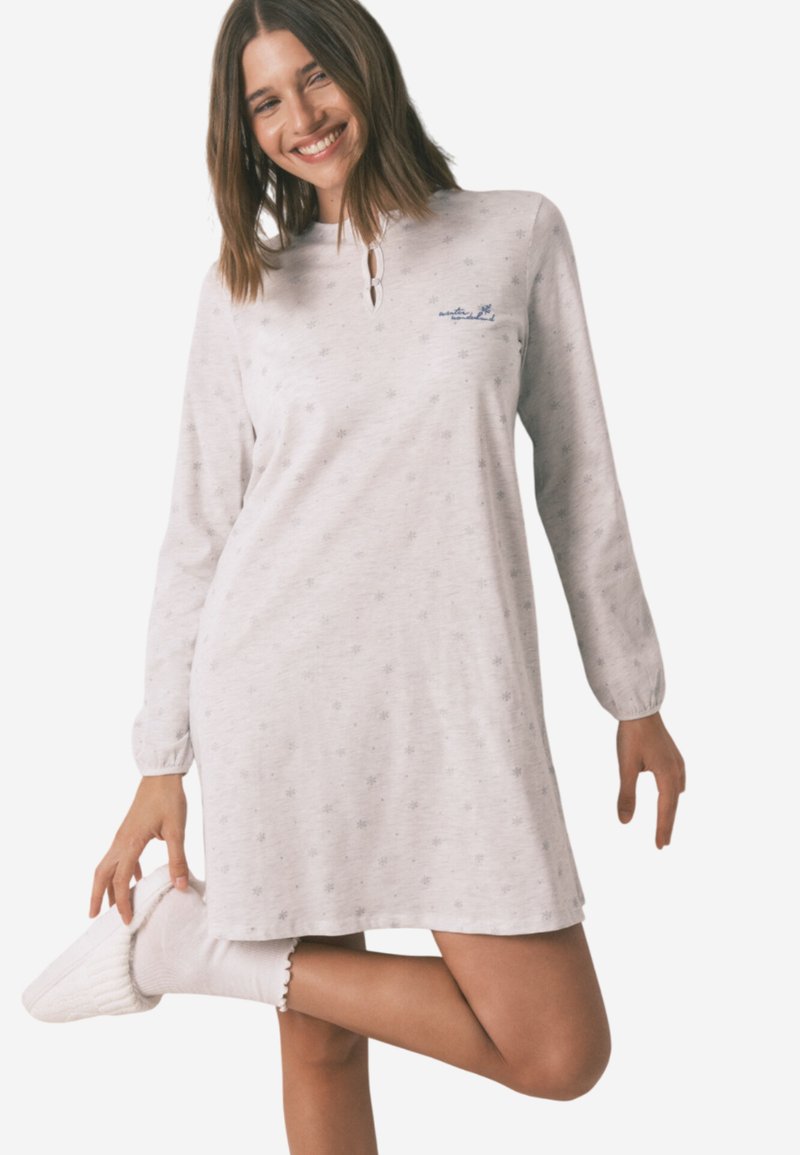 Lys grå langærmet natkjole med nøglehul-nakke, med subtile stjerne mønstre, og parret med hvide teksturerede sokker og tøfler.