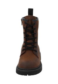 Brązowe skórzane botki na sznurówki z czarną podeszwą i pętelką, widok z przodu.