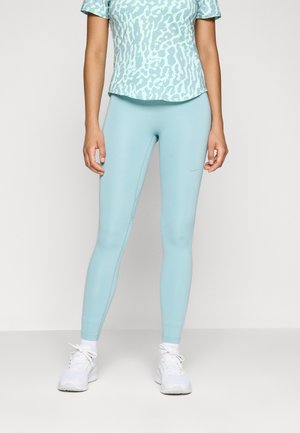 Light blue athletic leggings with a smooth texture, paired with a matching patterned short-sleeve top and white athletic shoes.