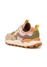Sneaker mit einem Obermaterial aus verschiedenen Materialien, das beige, rosa und grüne Akzente aufweist, strukturierte Überzüge, eine gepolsterte Sohle und eine gelbe Zuglasche.