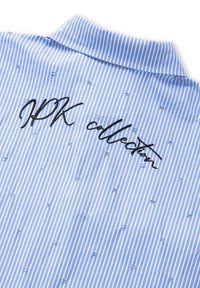 Blauw-wit gestreepte shirt met een klassieke kraag, textuurstof en zwarte geborduurde tekst met de tekst "JPK collector."
