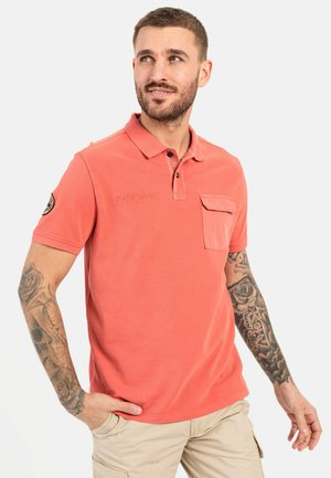 Koralfarvet poloshirt med krave, korte ærmer, en brystlomme og broderet "EXPLORERS" tekst. Har et tekstureret stof og en dekorativ lap.