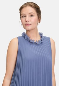 Robe sans manches bleu clair avec des plis verticaux et un col froncé texturé. Tissu doux avec un léger éclat et un design fluide.