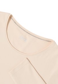 T-shirt à manches courtes et col rond de ton pêche avec une texture lisse et un logo en argent au niveau du col. Équipé d'une manche repliée.