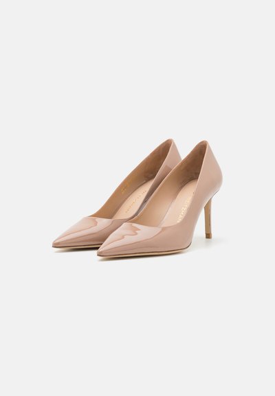 Nude lakierowane szpilki z wąskim obcasem typu stiletto i gładkim, błyszczącym wykończeniem. Subtelne oznakowanie wewnętrzne widoczne.