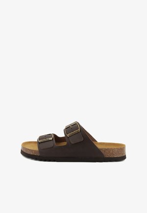 Sandalo marrone con due fibbie di metallo regolabili e soletta in sughero su sfondo bianco.