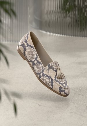 Flache Loafers in einem beigen und braunen Schlangenmuster, mit einer dekorativen Quaste und glattem Lederbesatz auf einem niedrigen Holzabsatz.