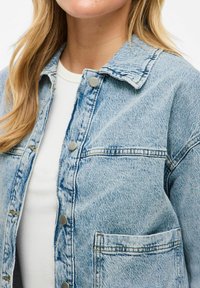Hellblaues Jeansjacke mit Kragen, Druckknöpfen und Fronttasche. Verfügt über einen strukturierten Stoff mit verblassten Details und sichtbaren Nähten.