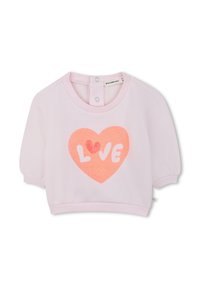 Sweat-shirt rose avec des manches courtes bouffantes, arborant un grand motif en forme de cœur pailleté avec le mot "LOVE" en blanc. Fermeture à pressions à l'arrière.
