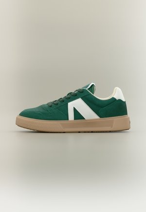 Pantof sport verde din piele întoarsă, cu accente albe, având o talpă din cauciuc texturată și un design distinctiv al logo-ului pe lateral. Închidere cu șireturi.