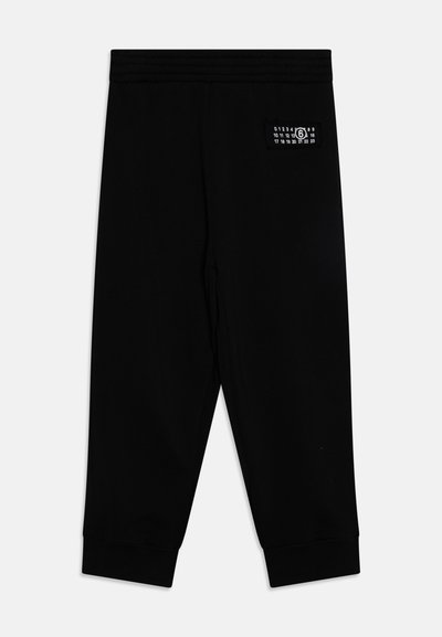 Μαύρες αθλητικές φόρμες με μαλακή υφή, ελαστική μέση και στενές μανσέτες. Διαθέτει μια μικρή ετικέτα με αριθμητικά γραφικά στην πίσω τσέπη.