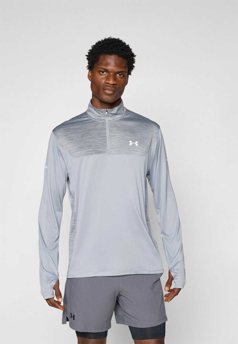 Svijetlosivi dugosleeve atletski gornji dio s ovratnikom na munje, s teksturiranim dizajnom na gornjem dijelu i Under Armour logom u bijeloj boji.