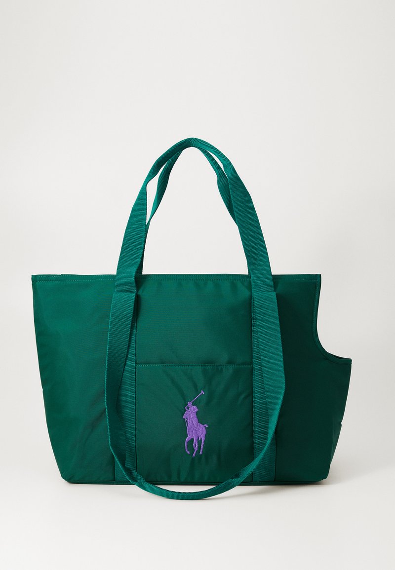 Zöld nylon bevásárlótáska nagy külső zsebbel és lila hímzett logóval. Két erős pánttal rendelkezik a hordozáshoz.