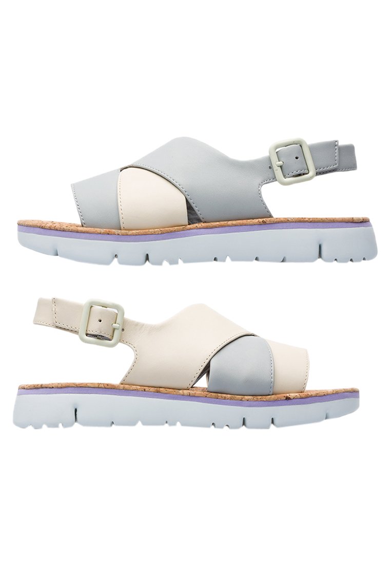 Sandali in pelle con una combinazione di colori grigio chiaro e crema, dotati di una soletta in sughero e una cinturino con fibbia sul lato.