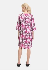 Blumenkleid in lila und rosa Tönen, mit kurzen Ärmeln, knielang und lockerer Passform. Verfügt über eine subtile Nahtdetails auf der Rückseite.