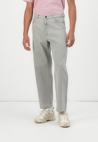 Light gray straight-leg jeans with a classic five-pocket design, button closure, and subtle stitching details. Worn with cream-colored sneakers.