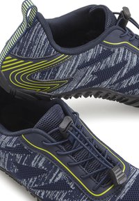 Marineblaue Sportschuhe mit einem strukturierten Mesh-Obermaterial, das weiße und graue Muster aufweist, elastischen Schnürsenkeln und einem grünen Akzent an der Seite.