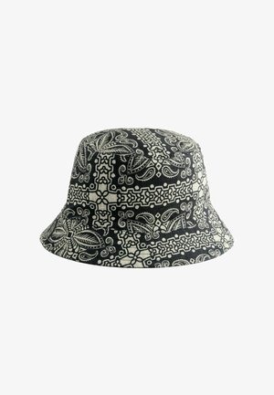 Črno-bela vedra kapa z zapletenimi cvetličnimi in geometrijskimi vzorci, izdelana iz blaga z gladko teksturo in okroglim vrhom.