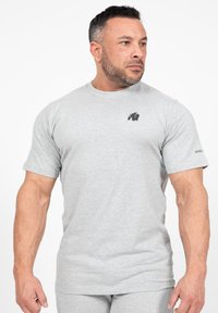 Grijze t-shirt met korte mouwen van een katoenmix, met een zwart gorilla-logo op de linkerborst en subtiele branding op de mouw.