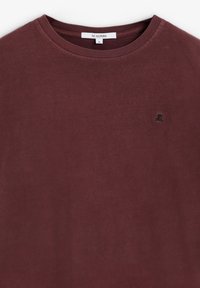 Camiseta de cuello redondo burdeos hecha de algodón con una textura suave. Presenta un pequeño logotipo bordado en el lado izquierdo del pecho. Talla: S.