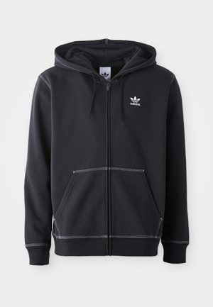 Schwarze Zip-Up-Hoodie aus weichem Stoff mit einer vorderen Kängurutasche, weißen Nähakzenten und einem kleinen weißen Logo auf der Brust.