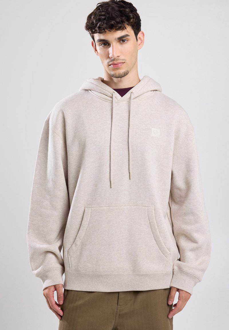 Beige Kapuzenpullover aus weichem Stoff, mit einer vorderen Kängurutasche, einer verstellbaren Kordelzugkapuze und kleinem Logo auf der Brust.