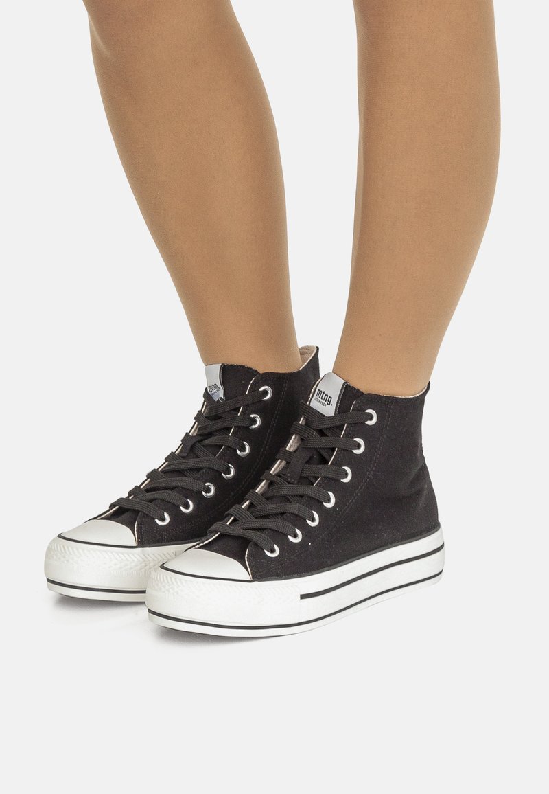 Sneaker alte nere in tela con suole in gomma bianca, dotate di lacci neri, occhielli in argento e una punta testurizzata.